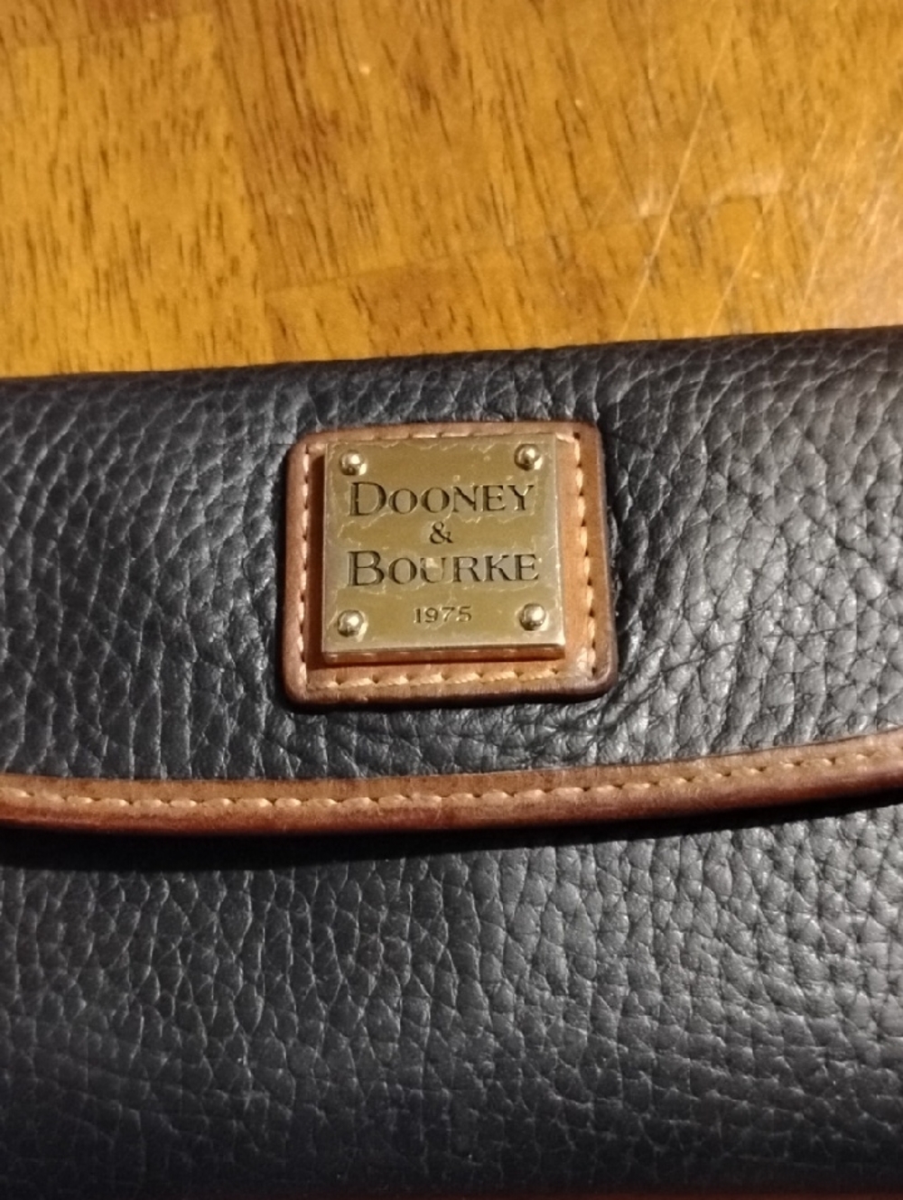 Dooney & Bourke Black Leather Wallet with Brown Trim and Brass Plaque